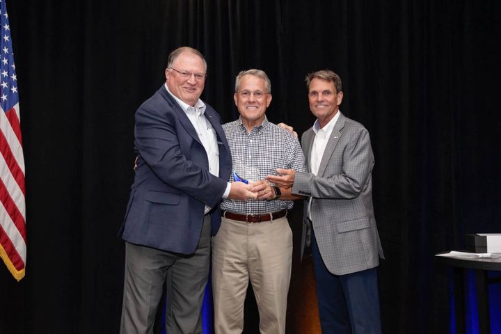 Frank Hackett (center), the retired CEO of the National Auto Auction Association, accepts award from Tony Long, IARA executive director, and President Seger. - Photo: IARA